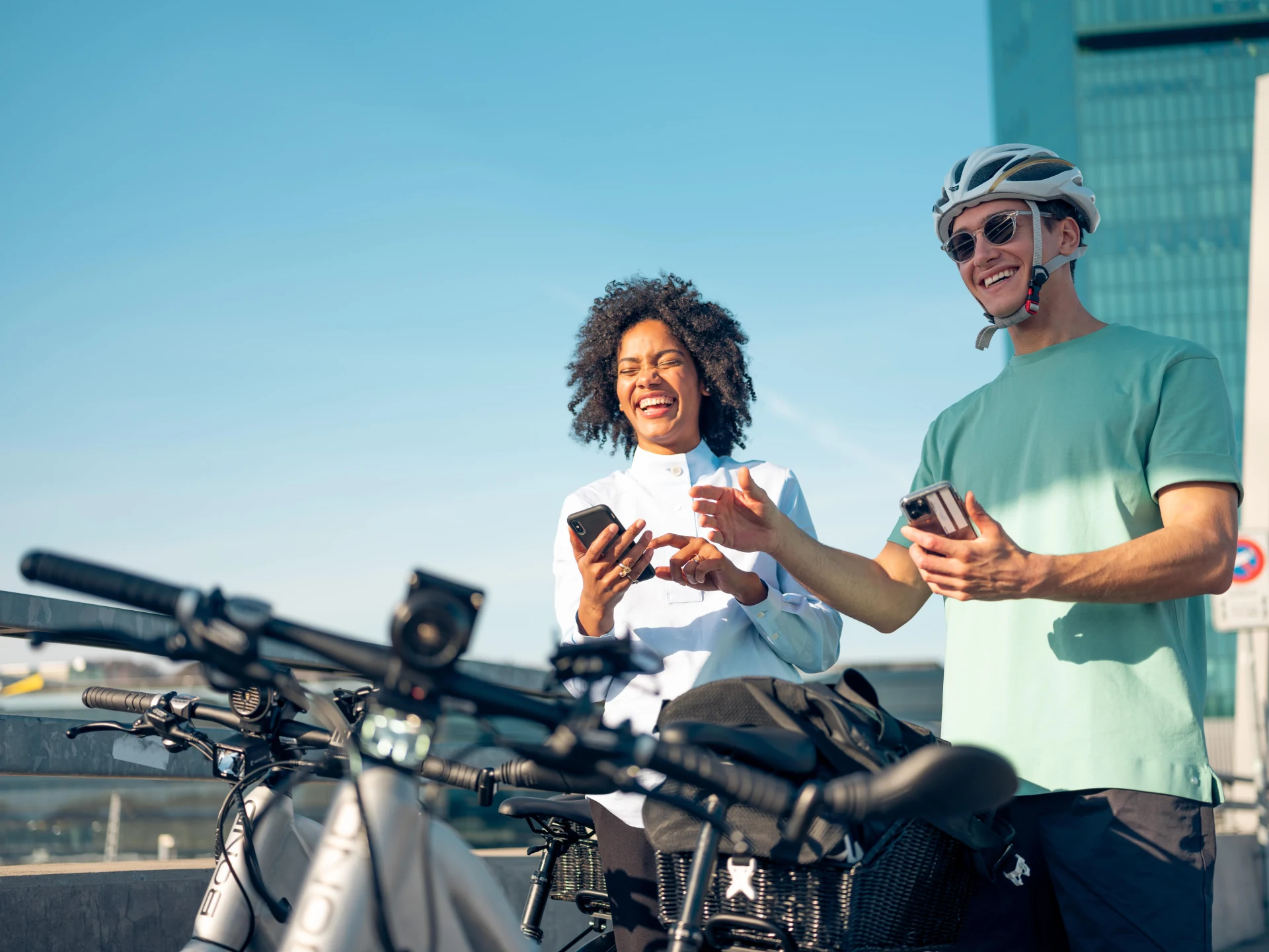 Two people with e-bikes using a mobile app